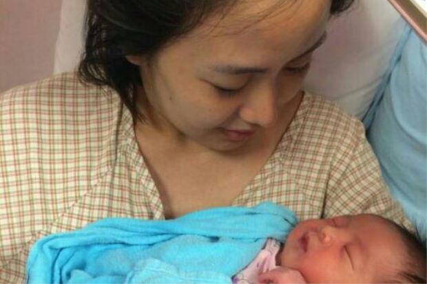 Koo Kien Keat's wife Audrey Tan Su Ven is holding their newborn son Dayson.
