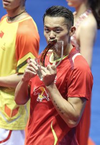 Lin Dan kisses his fifth China Masters badminton trophy