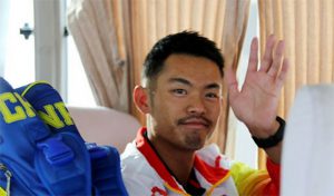 Lin Dan waves from inside the bus
