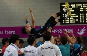 Korean shuttlers throw Lee Hyun-il up in the air after wining Asian Games men's team gold