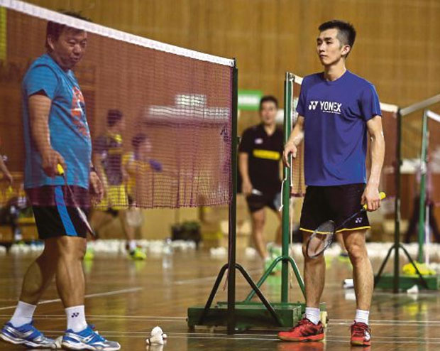 Coach Tey Seu Bock gives advice to Chong Wei Feng during the training session.