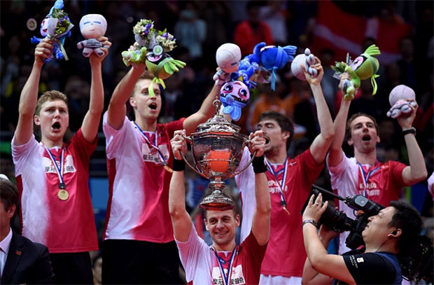 Hans-Kristian Vittinghus (C) of Denmark holds the Thomas Cup trophy between his teammates during the awards ceremony. (photo: AFP)