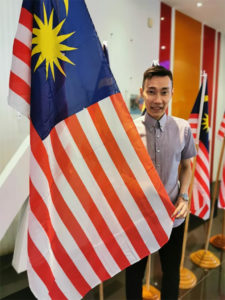 Lee Chong Wei stands next to the Malaysia flag. (photo: Lee Chong Wei's Facebook)
