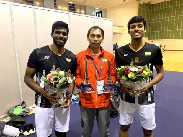 Flandy Limpele poses with India's men's doubles players Satwiksairaj Rankireddy (left) and Chirag Shetty. (photo: AFP)