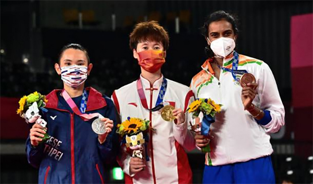 Chen Yufei (middle), Tai Tzu Ying (left), PV Sindhu pose for pictures at the Olympic award ceremony. (photo: Pedro Pardo/AFP)