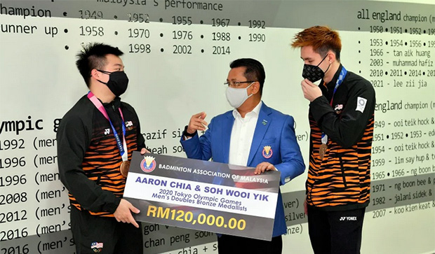 Aaron Chia/Soh Wooi Yik receive a check of RM120,000 from the President of BAM, Tan Sri Mohamad Norza Zakaria. (photo: Bernama)