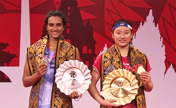 An Seyoung (R) shares the podium with PV Sindhu during the 2021 BWF World Tour Finals award ceremony.