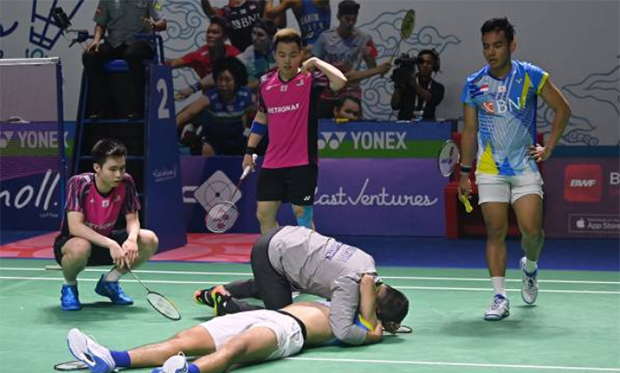 Aaron Chia/Soh Wooi Yik, and their coach - Rexy Mainaky, are checking on the injured Yeremia Rambitan. (photo: Shi Tang/Getty Images)