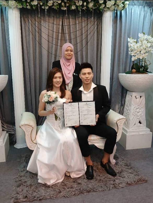 Ong Yew Sin and Aya Ohori at their marriage registration ceremony in Melaka, smiling alongside the registration officials. (Photo: NRD Melaka)